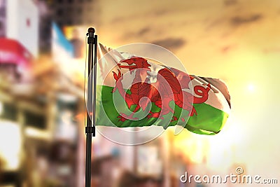 Wales Flag Against City Blurred Background At Sunrise Backlight Stock Photo