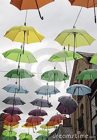 Wales, the city of Caernarfon. Coloured umbrellas. A narrow shopping street. Stock Photo