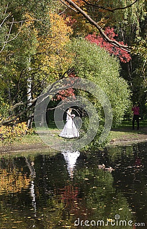 Walk in the park in the fall. reflection in water. Bride Stock Photo