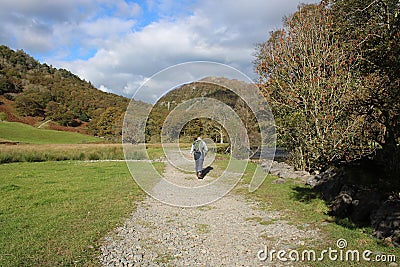 Walker with rucsac on footpath in Borrowdale, UK Stock Photo