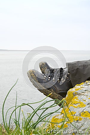 Walking boots with sea in background Stock Photo