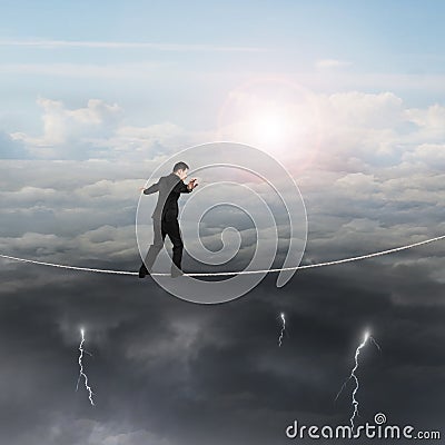 Walking businessman balancing on rope with sun sky cloudy lightning Stock Photo