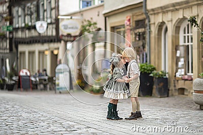 Walking children on the street.The relationship of a girl and a boy . Photos in retro style . Pavers in the city center.Summer. Stock Photo