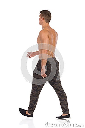 Walking Half Naked Man In Camo Pants Rear View Stock Photo