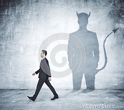 Walking man with devil shadow Stock Photo