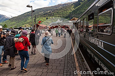 Walking near Flamsbana railroad wagons in Flam with high hills in the background, Vestland, Norway Editorial Stock Photo