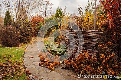 Walking in november garden. Late autumn view with rustic fence Stock Photo