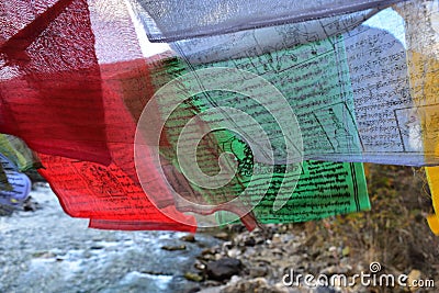 walking suspension bridge over the river with colorful prayer flags in Bhutan Stock Photo