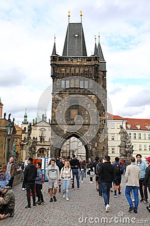 The walking tourists pass through an acre and come to Karlov Bridge. Editorial Stock Photo