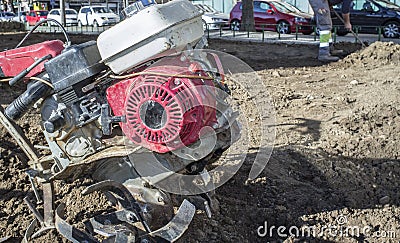 Walking tractor equiped with plow at urban park close to working Stock Photo
