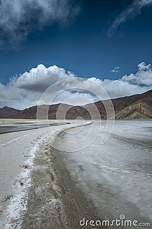 A walkway amidst the fully frozen Pangong Lake, inviting you to explore the captivating natural landscape on a sunny day Stock Photo