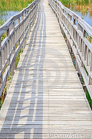 Walkway or walk path wooden bridge in lake swamp or river. Stock Photo