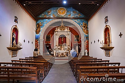 Walkway between wooden pews leading towards crucifix in church Editorial Stock Photo