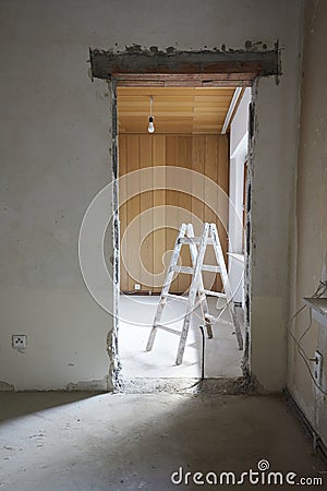 Wall breakthrough for a room door, behind it a painter's ladder Stock Photo