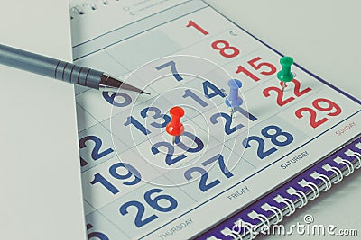 Wall calendar and pen, important days are marked with knops Stock Photo