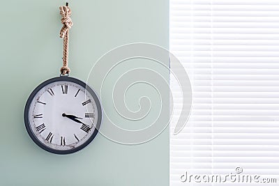 Wall clock with rustic design in a home office, in analog form, pointing to 3 in the afternoon using roman numerals Stock Photo