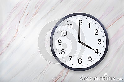 Wall clock show four o`clock on marble texture. Office clock show 4pm or 4am Stock Photo