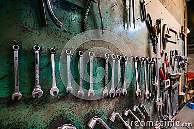 Wall with different metal instruments in little factory room Editorial Stock Photo