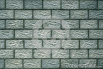 The wall of the house is made of concrete blocks. Aged blue-green tinted background or wallpaper. The seams form a pattern similar Stock Photo