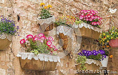 Wall in the medieval center of Spello with pots of flowers Stock Photo