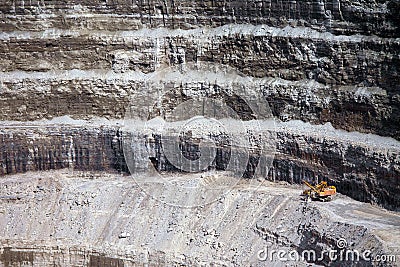 Wall of a modern diamond mine featuring big yellow machinery Stock Photo