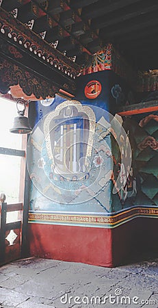 Wall paintings and prayer bell near the window inside the Punakha Dzong dating from 1637, Punakha, Bhutan Stock Photo