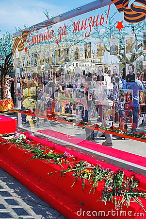 A wall with photographs. Many flowers put by the wall. Editorial Stock Photo