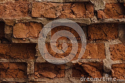 The wall of red dilapidated brick. The ruined brick wall close-up. Facade of a destroyed brick building. Pattern, texture, backgro Stock Photo