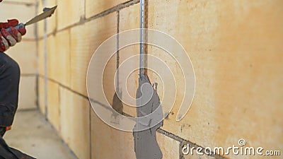 Wall repair with mortar. Plasterer at work. Fastening building beacons to the wall with mortar. Stock Photo