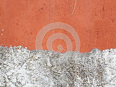 wall texture with a section painted orange and another rustic white with details of the passage of time Stock Photo