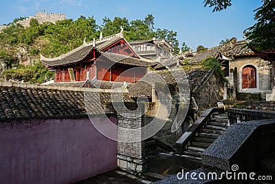 Walled ancient tile-roofed buildings at hill foot in morning Editorial Stock Photo