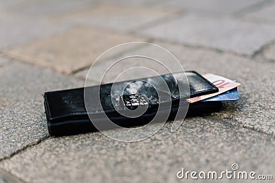 The wallet with coins on sidewalk street, forgotten money Stock Photo