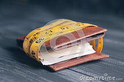 Wallet with money tied with a measuring tape Stock Photo