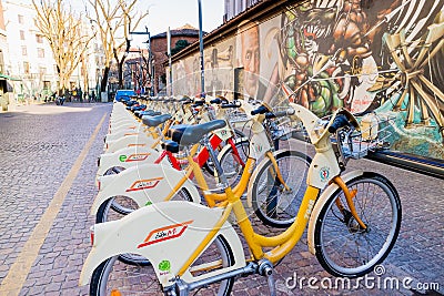 Walls artistics graffitis and bicycles station in Milan, Italy Editorial Stock Photo