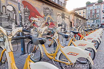 Walls artistics graffitis and bicycles station in Milan, Italy Editorial Stock Photo