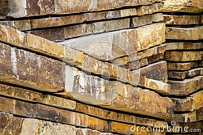 Walls built of sliced sandstone in angles - Stone background Stock Photo