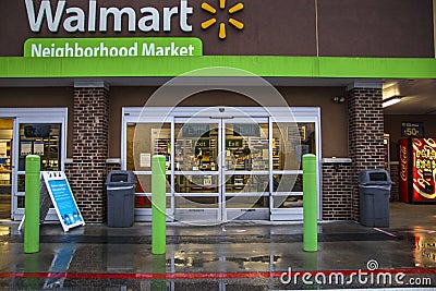Walmart neighborhood grocery store in the rain entrance and covid-19 sign Editorial Stock Photo