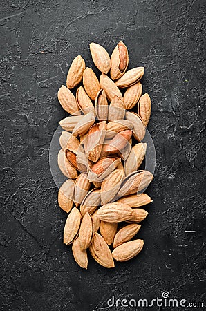 Walnut almonds in the shell. Nuts on a black stone background. Top view. Stock Photo