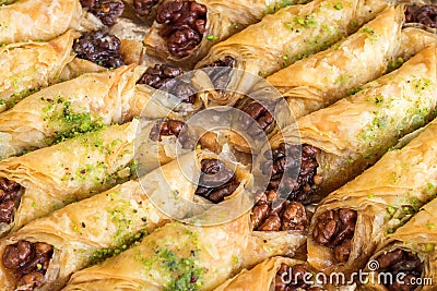 Walnut baklava rolls on an aluminium tray. Turkish layered pastry dessert filled with walnuts Stock Photo