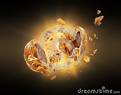 Walnut explodes into pieces in the dark Stock Photo