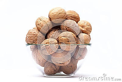 Walnuts lie in a glass bowl isolated on white Stock Photo