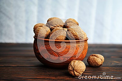 Walnuts, nuts in pottery on a wooden table. Stock Photo