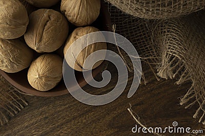 Walnuts plate on wooden table with textile. Stock Photo