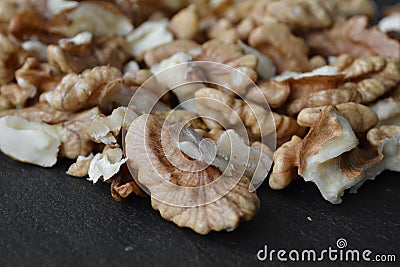 walnuts scattered on a black table Stock Photo