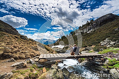 Wanderluster hiker sitting with dog in mountains Stock Photo