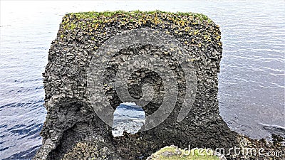 A tunneled basaltic rock on the coast of RauÃ°anes on the coast of Island Stock Photo