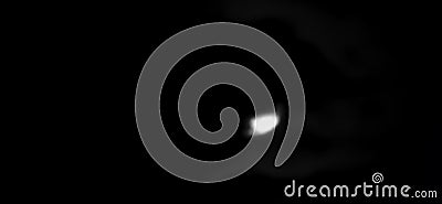 The waning Moon shines softly between the clouds, creating a calm and introspective atmosphere in the cloudy night. Stock Photo