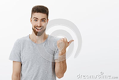Wanna see something curious. Portrait of enthusiastic happy handsome caucasian guy with beard and moustache pointing Stock Photo