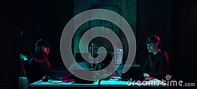 Wanted hackers coding virus ransomware using laptops and computers in the basement. Cyber attack, system breaking and Stock Photo