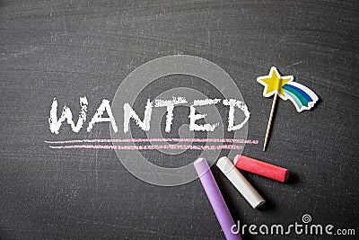 Wanted. Text and colored pieces of chalk on a dark blackboard Stock Photo